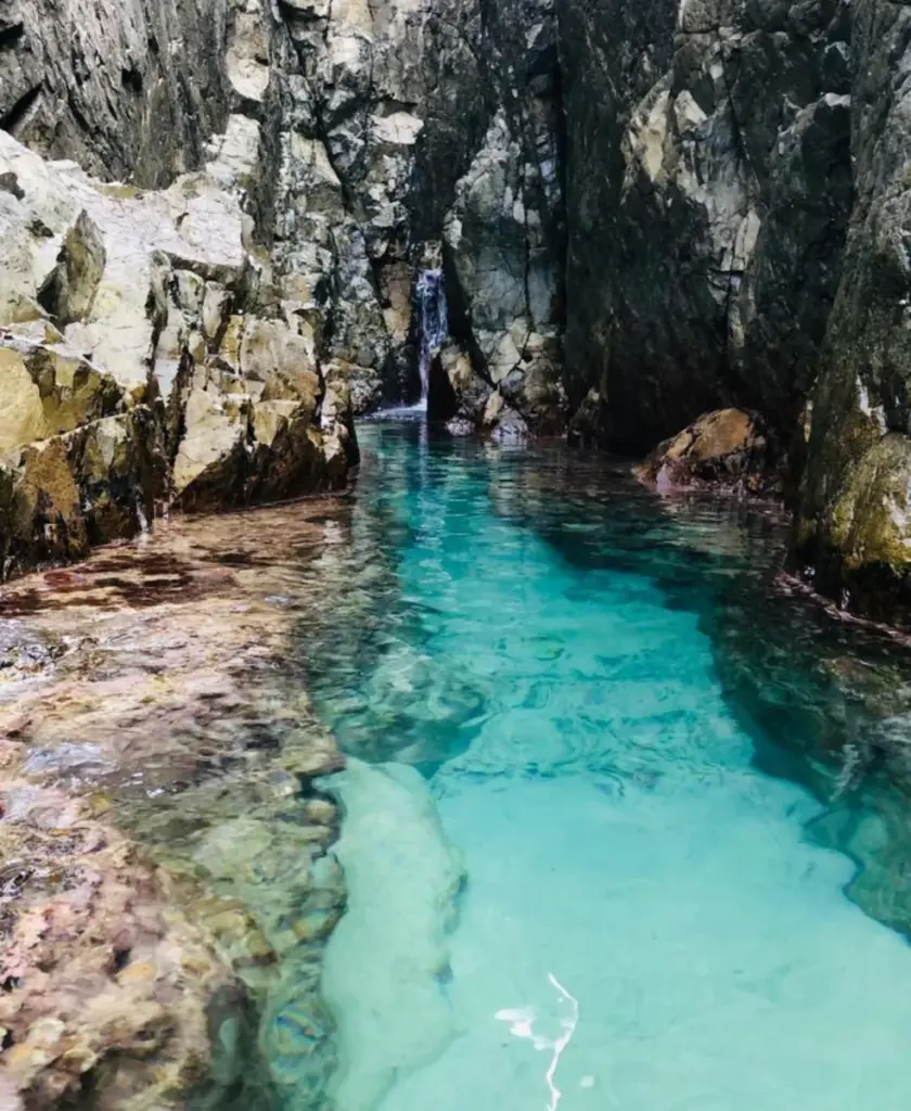 Água transparente em piscina natural entre rochas em Noronha